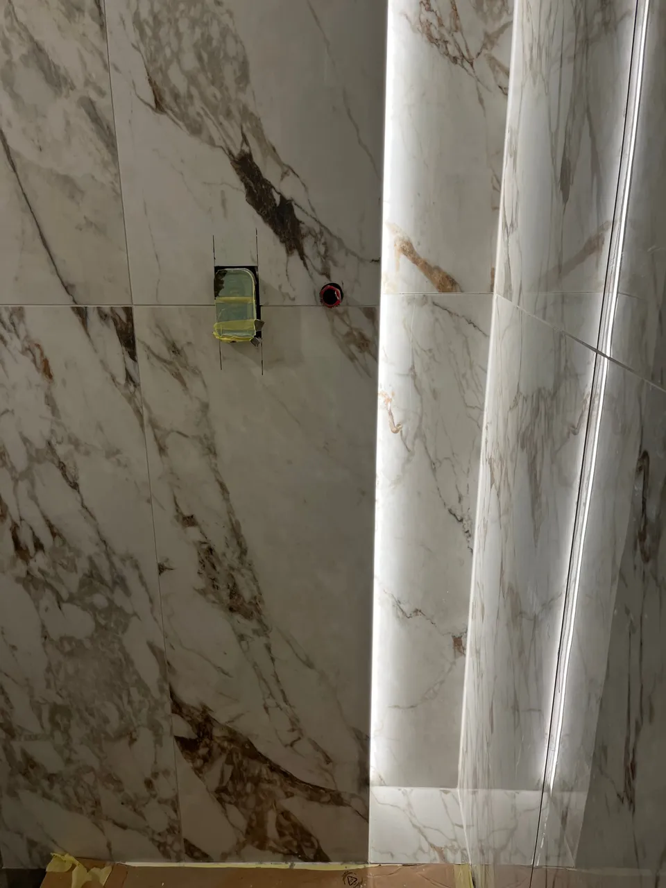 Detalj okomite niše s LED trakom između velikih ploča mramornog izgleda