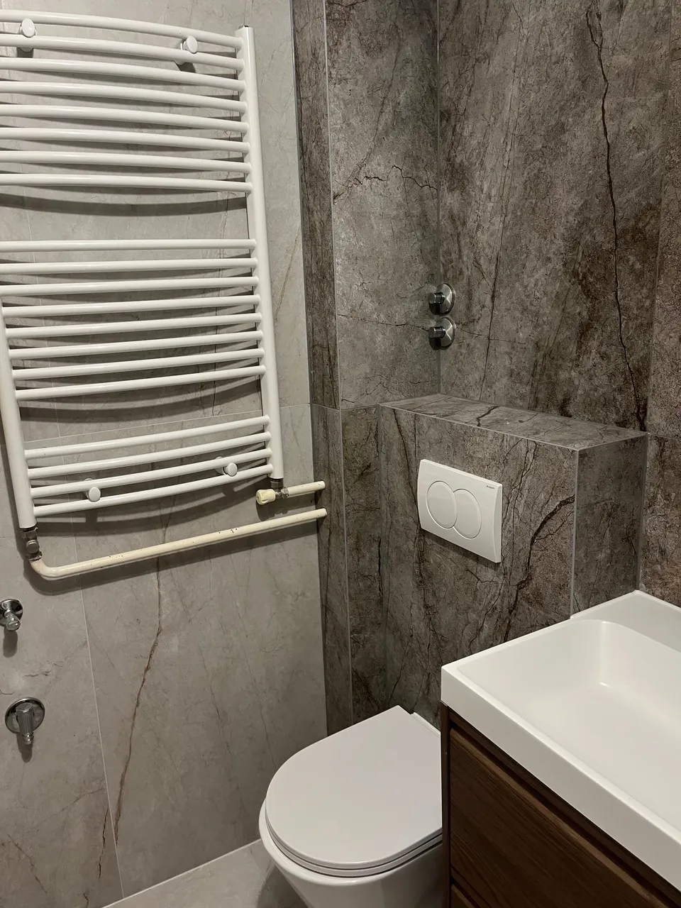 Radijator za ručnike, viseći WC i podžbukni vodokotlić s bijelom tipkom