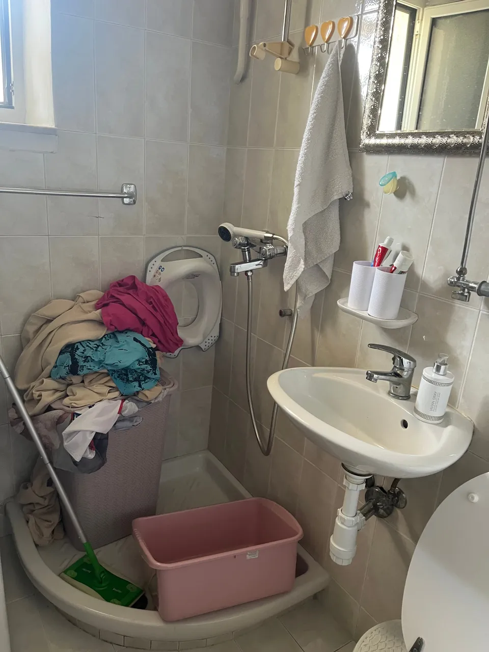 Stara tuš kada u kutu kupaonice, umivaonik i zidni tuš prije adaptacije