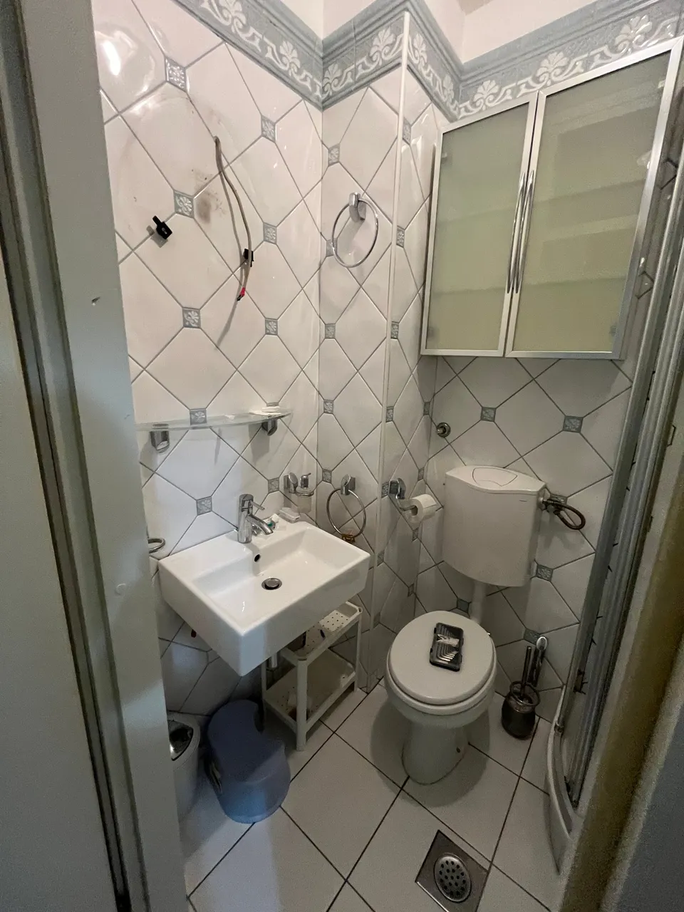 Mala kupaonica prije adaptacije: umivaonik, WC s vanjskim vodokotlićem i dijagonalno postavljene pločice