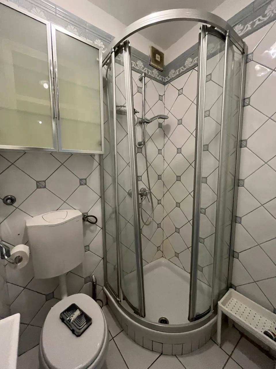 Stara polukružna tuš kabina i zidni ormarići s mat staklom