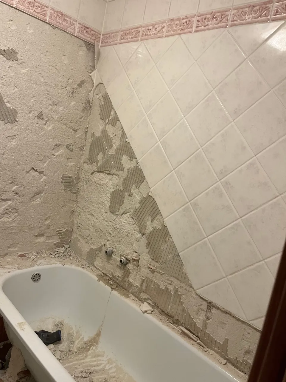 Stara kada i zidovi s djelomično skinutim pločicama